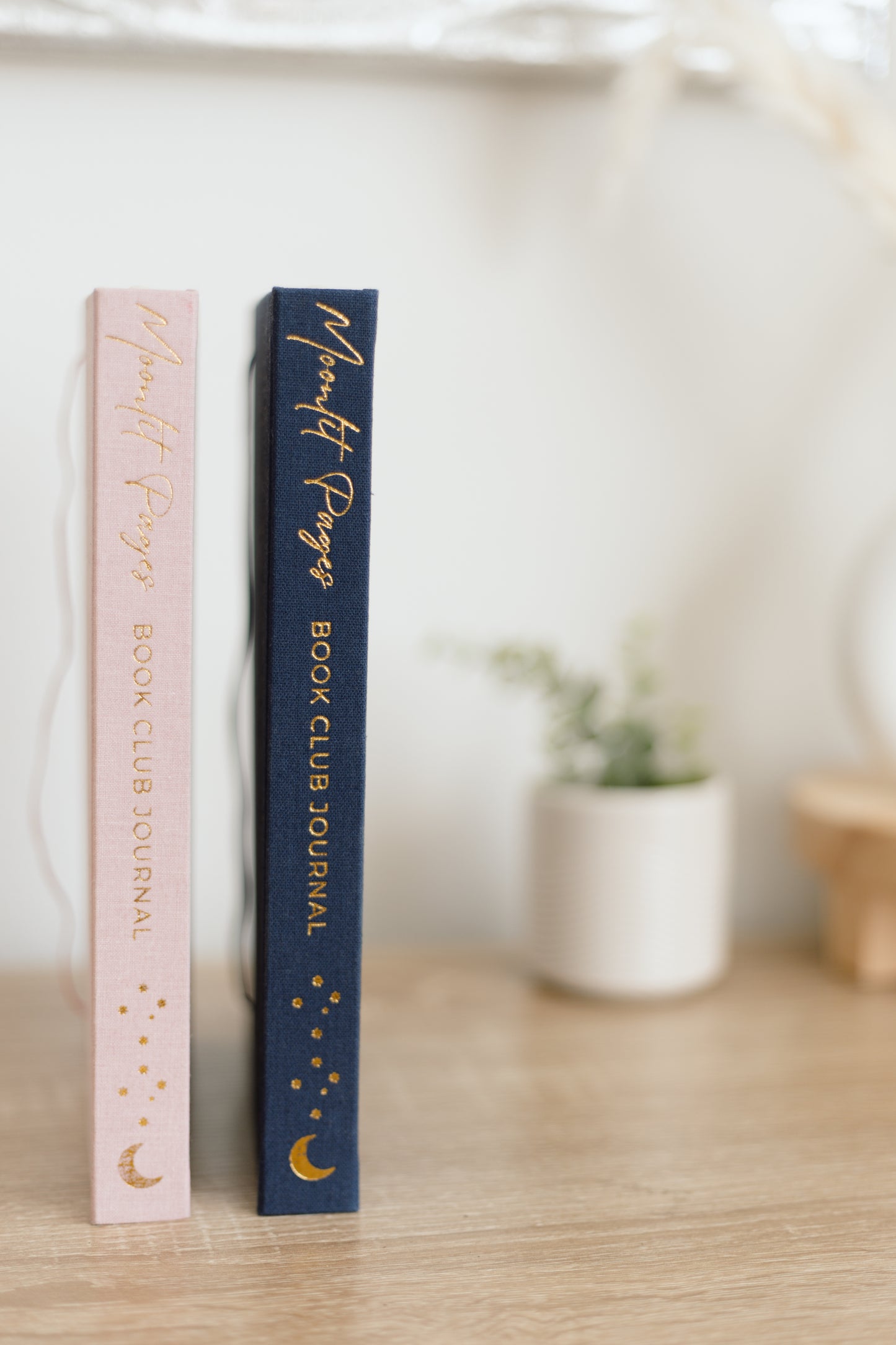 Moonlit Pages Book Club Journal bundle styled with navy and pink hardcover journals on a wooden table